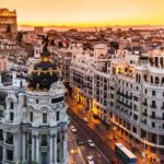 Madrid skyline at sunset with the Metropolis Building and Gran Vía glowing under warm golden light.